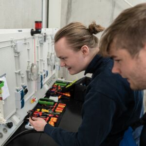 Zwei Auszubildende machen Prüfmessungen an Elektroinstallation