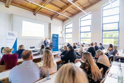 Menschen schauen sich Vortrag in Seminarraum der TAN in Kiel an
