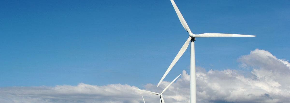 Reihe von Windkraftanlagen an der Küste - Erneuerbare Energien